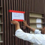 Corporation employees sealing a commercial building.