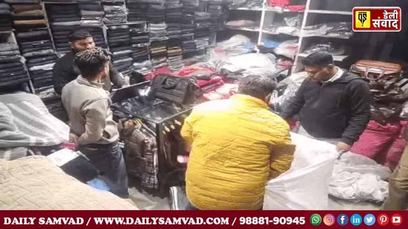 Adidas company officials seizing clothes from a shop in the presence of police.