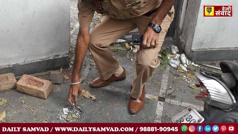 A police personnel collects evidence after a “blast” took place outside the residence