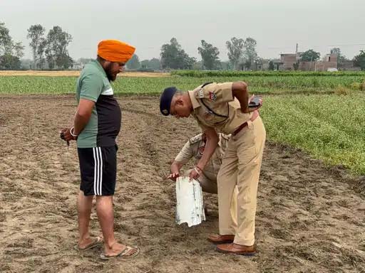 गुरदासपुर में खेतों में पड़े टुकड़े की जांच करते पुलिस अधिकारी।