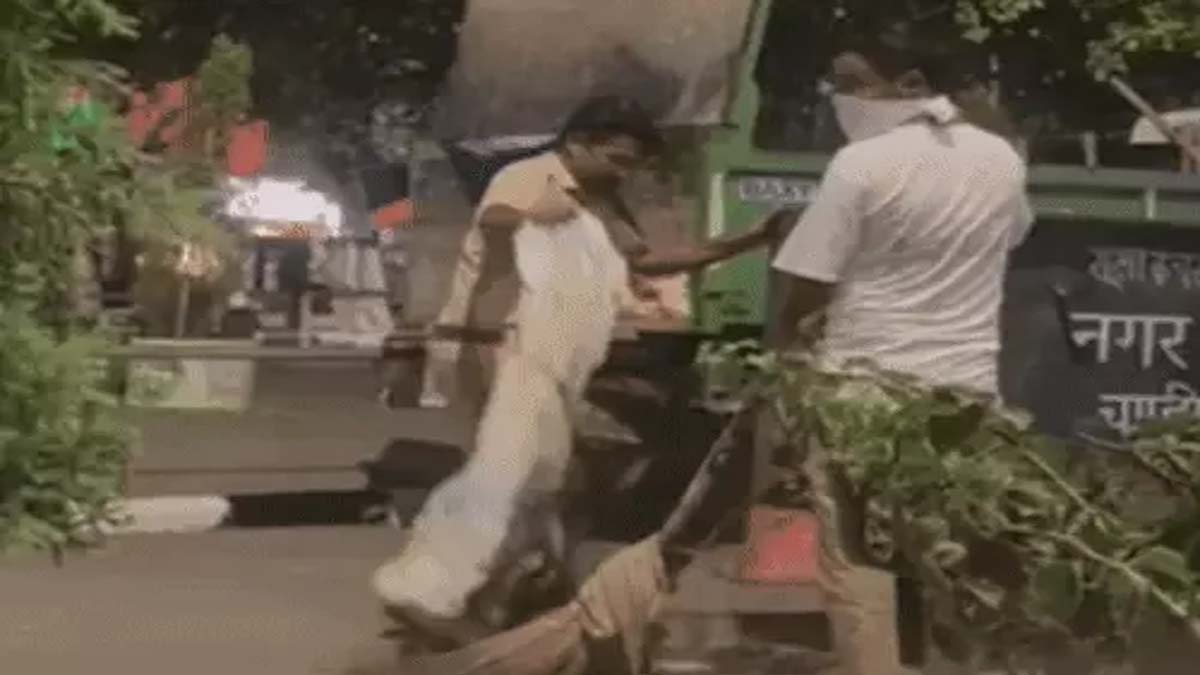 गाडी से गंदगी नीचे गिराते अधिकारी 